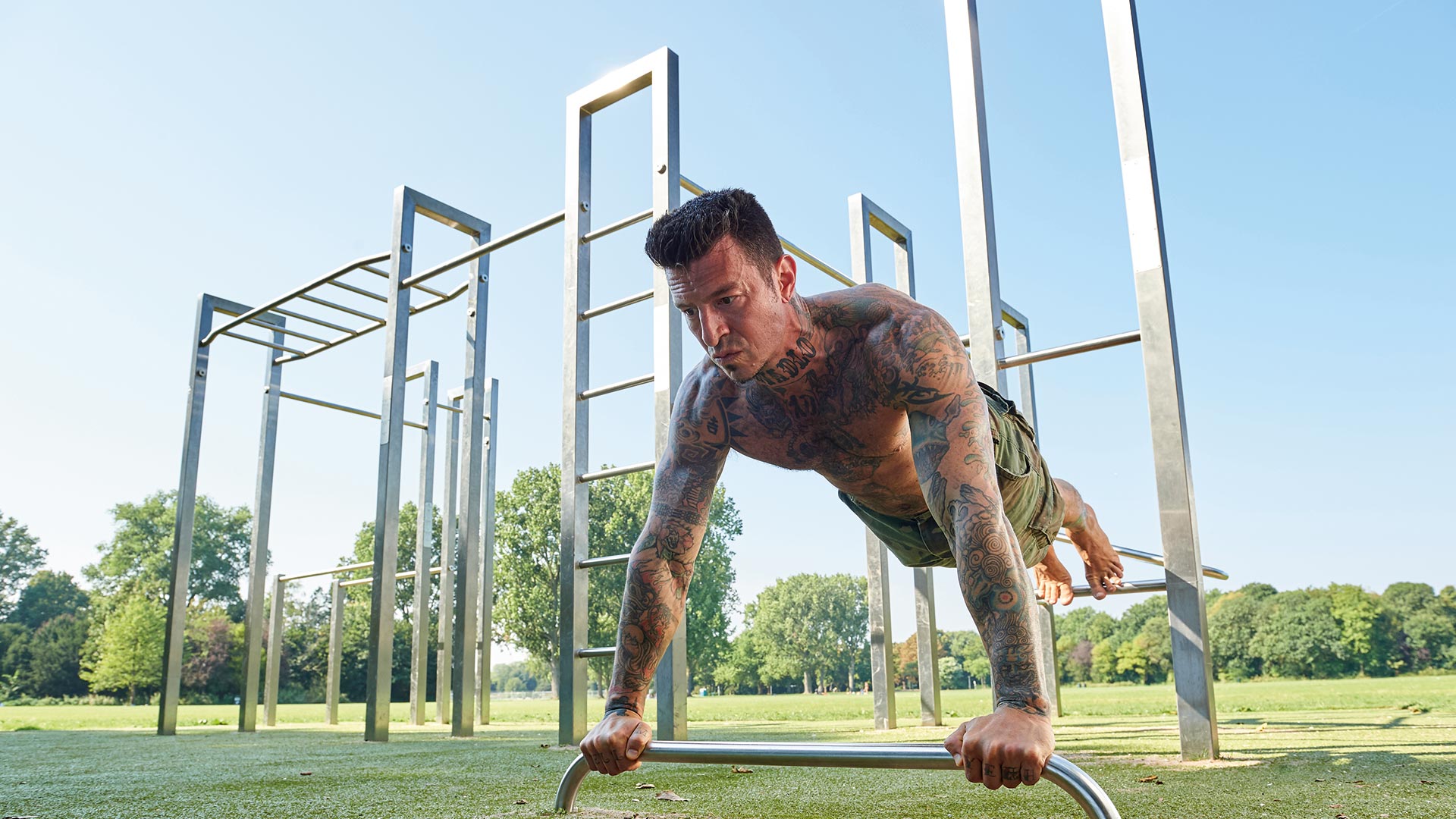 Calisthenics Anlage S-Feld und Stufenreckstangen - Mann macht Workout