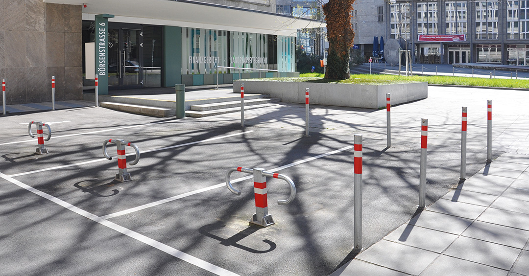 Sperrpfosten RUBI aus Stahl und Parksperre ARONA zur Sicherung eines Parkplatzes