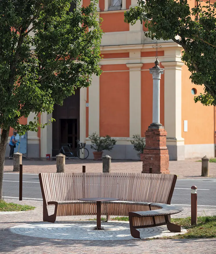 Halbrunde Sitzbank aus hellen Holz an einer Straße