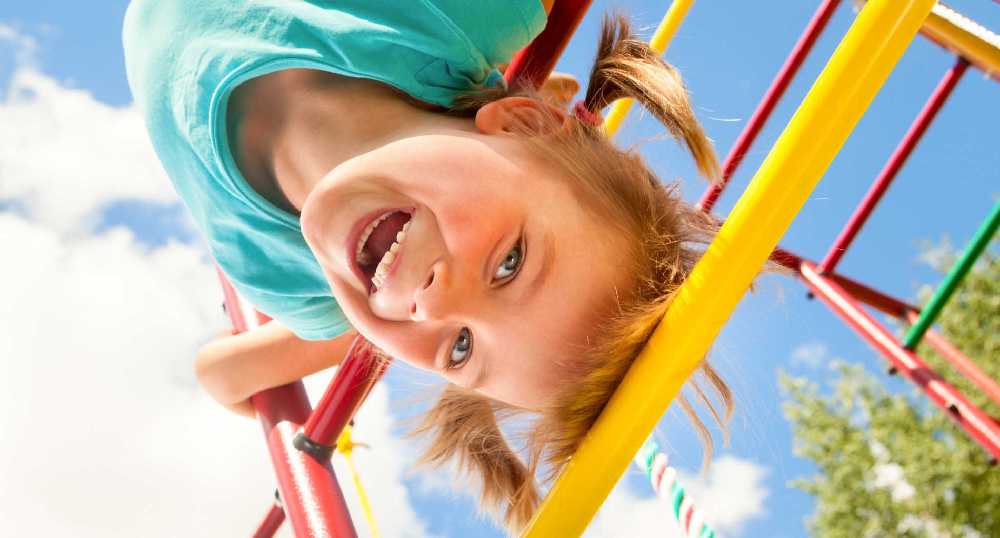 Mädchen über Kopf auf Klettergerüst