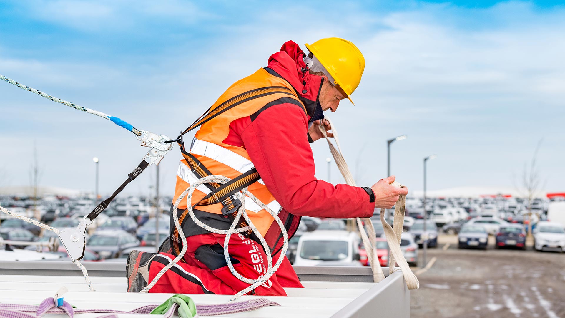 Montagearbeiter von ZIEGLER arbeitet auf einem Dach mit Seilen und Sicherheitsgurten