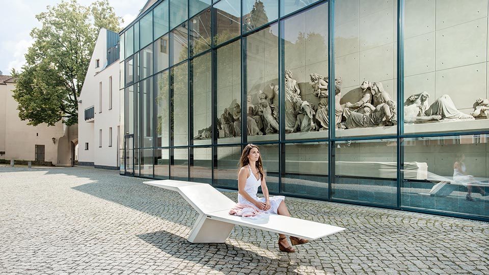 Exklusive Sitzbank in weiß auf der eine Frau sitzt