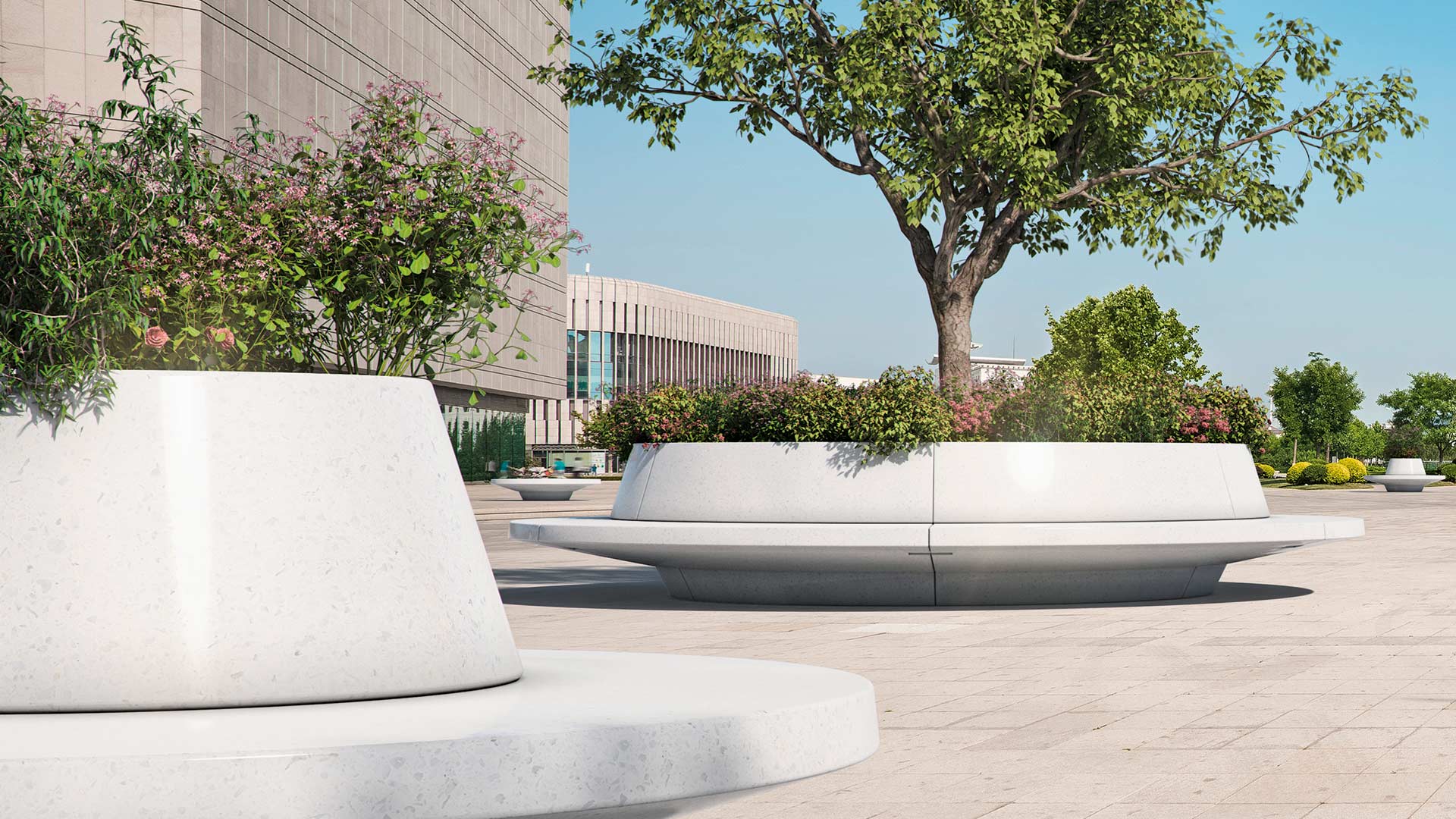 Große weiße Rundbänke, mit Pflanzbehälter in der Mitte