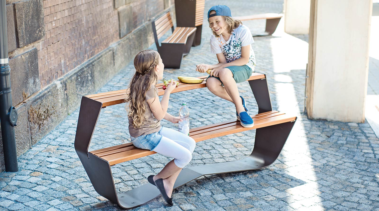 Kinder- und Jugendbank auf der zwei Kinder sitzen und sich unterhalten
