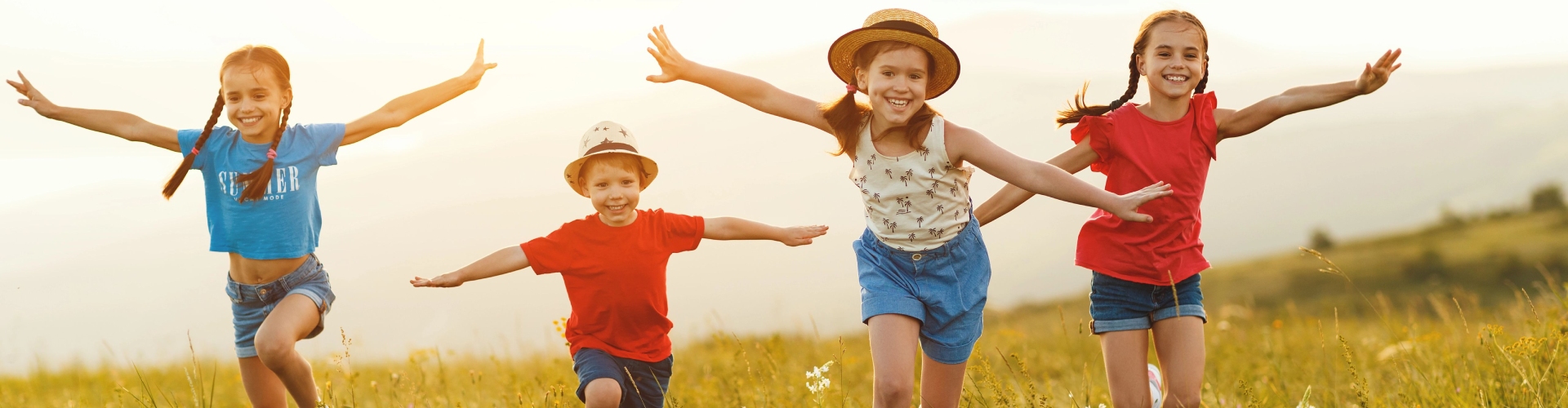 Kinder laufen im Sommer über ein Feld