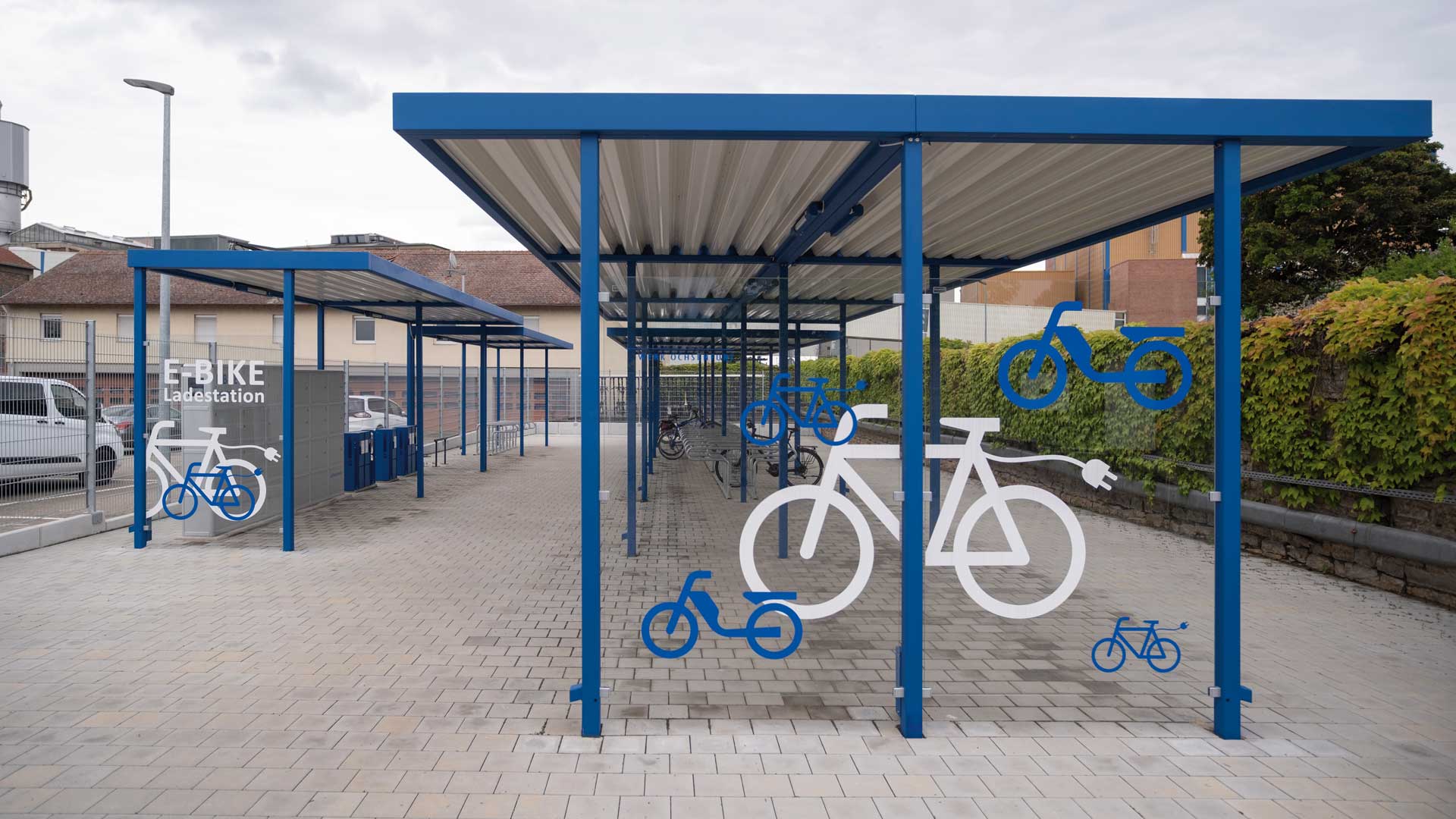 Fahrradüberdachung LUNA mit Fahrradparker HEDLAND, Fahrradständer HERVEY, Fahrrad-Abstellanlage VELO-CONNECTOR und E-Bike-Ladestellenschrank AMARO in Ochsenfurt Fahrradüberdachung LUNA mit Fahrradparker HEDLAND, Fahrradständer HERVEY, Fahrrad-Abstellanlage VELO-CONNECTOR und E-Bike-Ladestellenschrank AMARO in Ochsenfurt