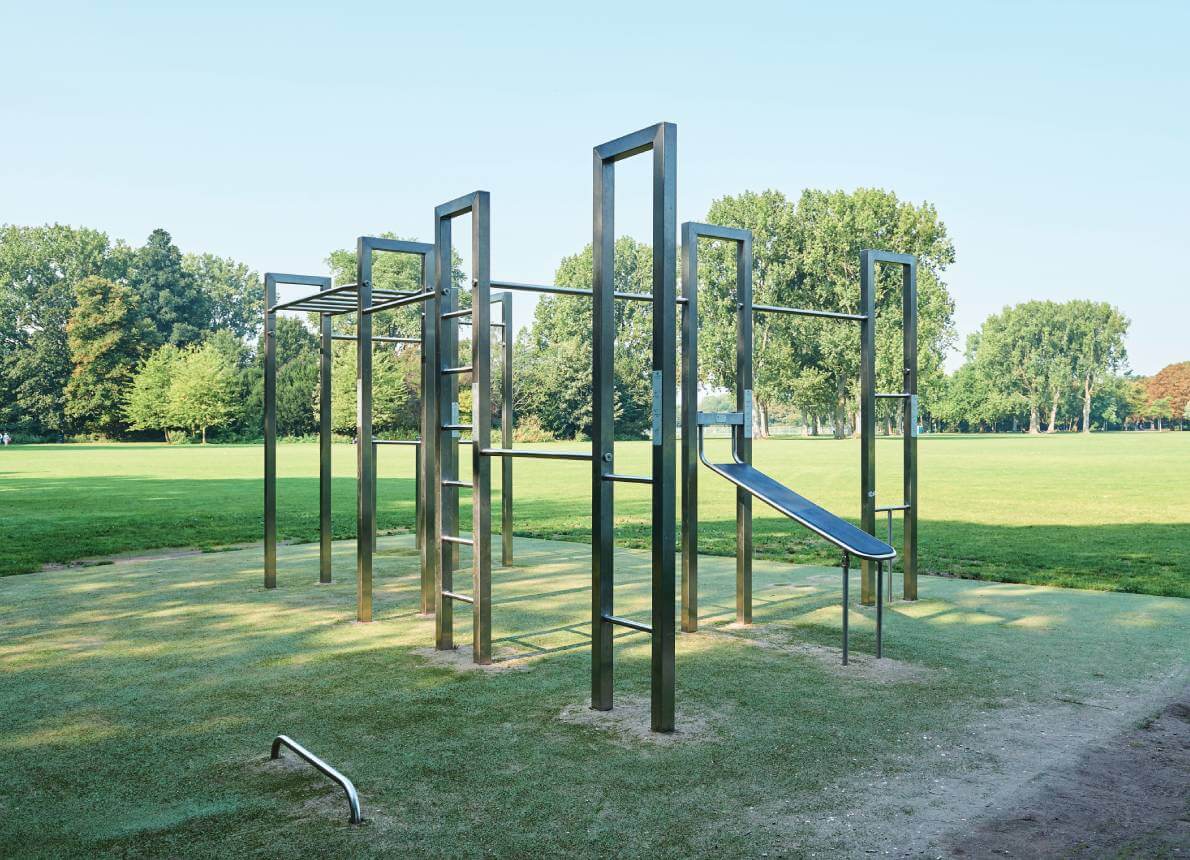 Calisthenics Anlage steht auf einer grünen Wiese vor einem Wald
