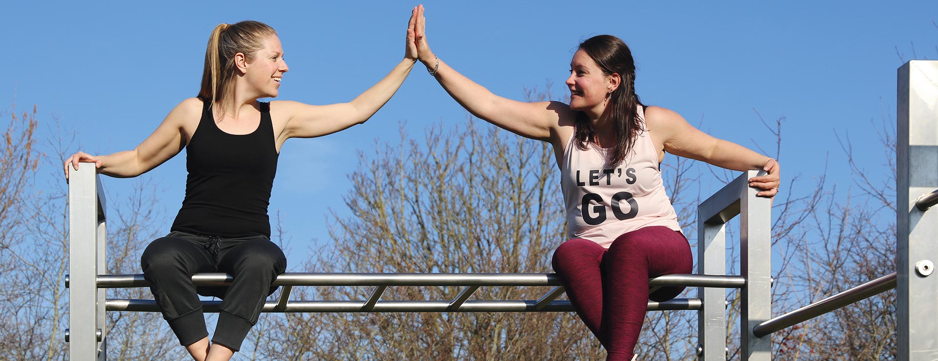Zwei Sportlerinnen sitzend auf Calisthenics Anlage XS Feld