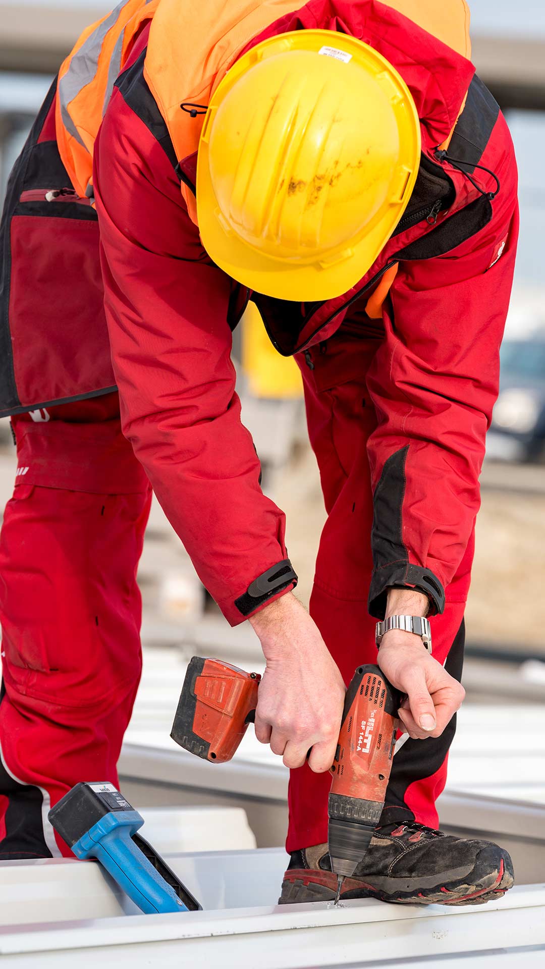 Mitarbeiter befestigt etwas an Stahlkonstruktion