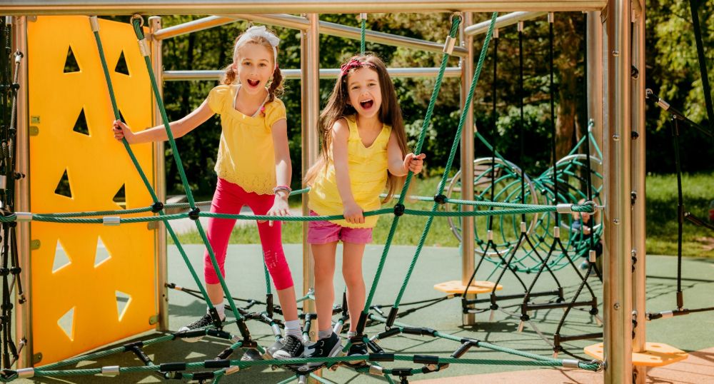 Zwei Mädchen spielen auf einem Klettergerüst