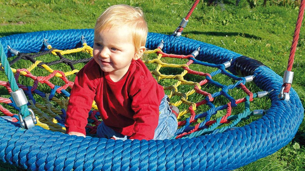 In der Nestschaukel MORITZ sitzt ein Kleinkind