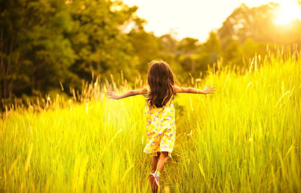 Kind läuft über eine Wiese
