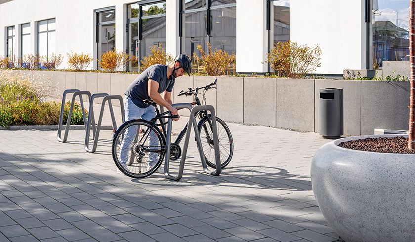 Fahradanlehnbügel, Mülleimer und Pflanzenbehälter vor einer Einkaufsmöglichkeit