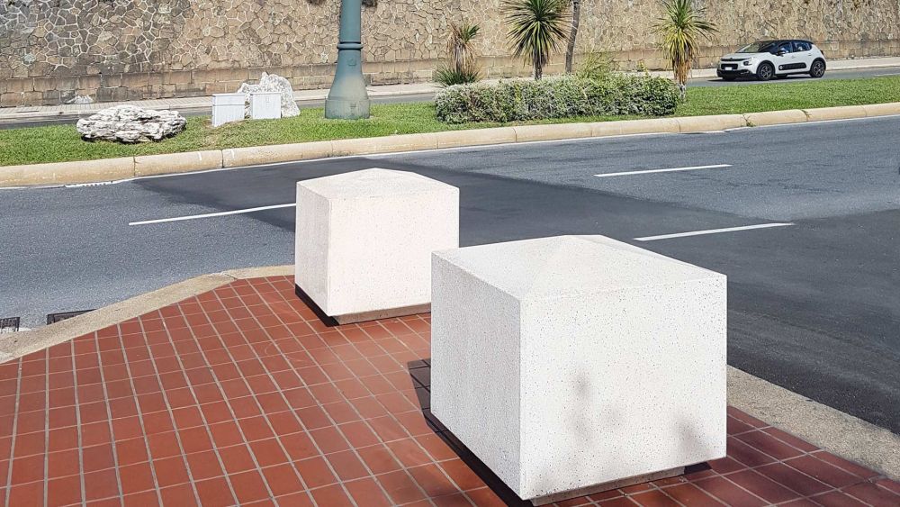 Zwei Beton-Poller auf Gehweg neben Straße, historische Villa