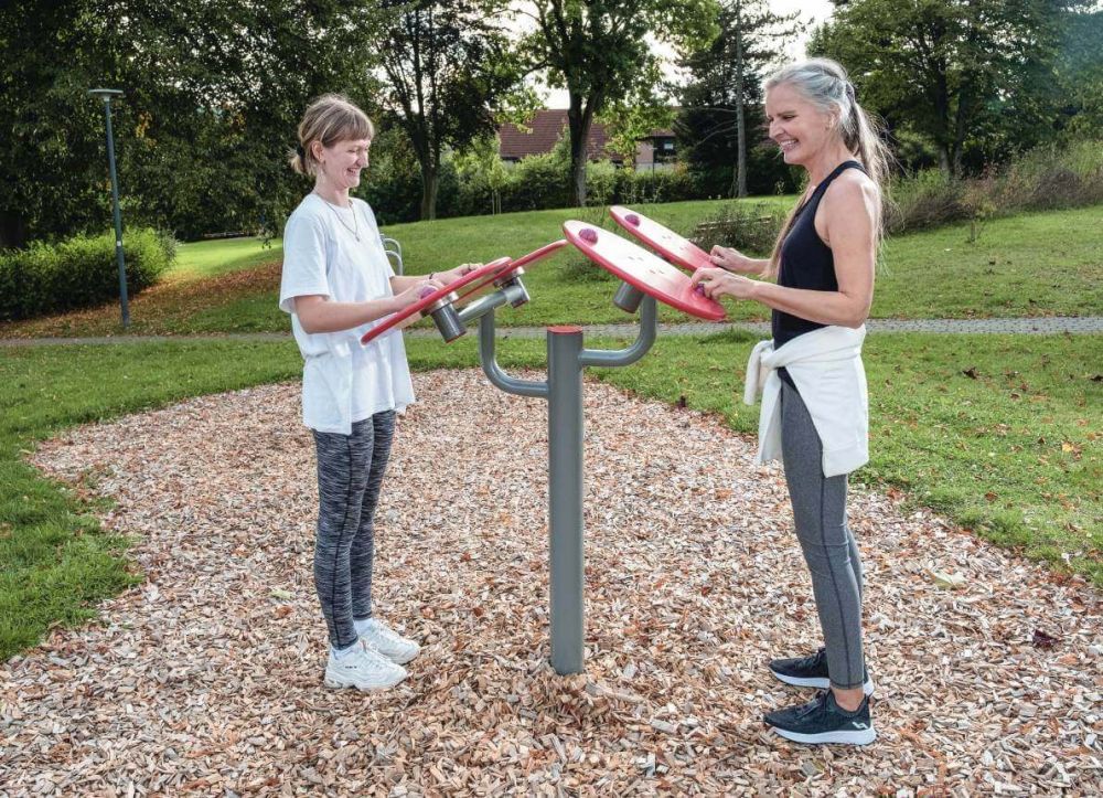 Zwei Frauen stehen an einer Outdoor Sportplatz Anlage in einem Park