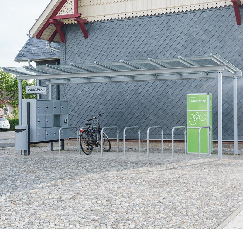 E-Bikes stehen sicher unter einer Überdachung mit Ladestationen.