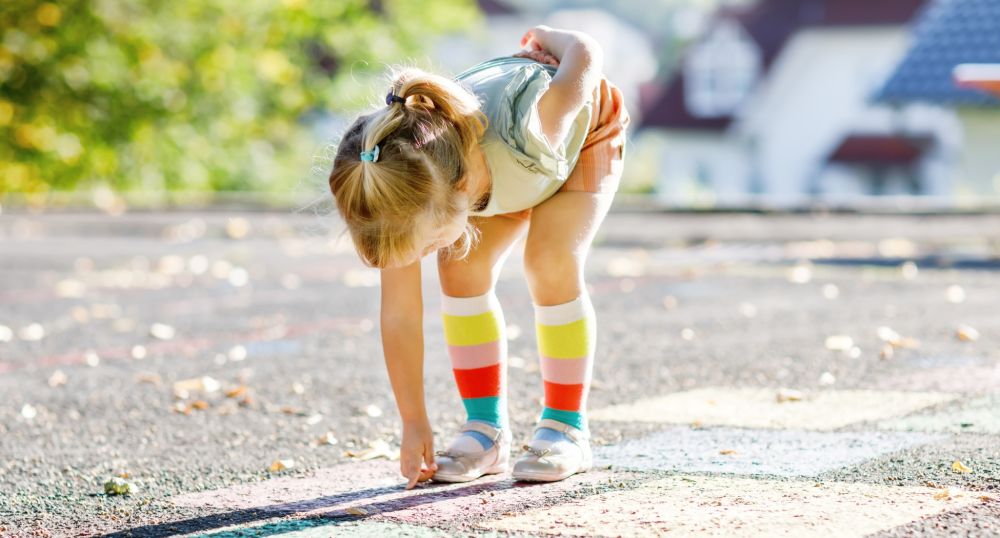 Kleines Mädchen auf einem Asphalt Boden